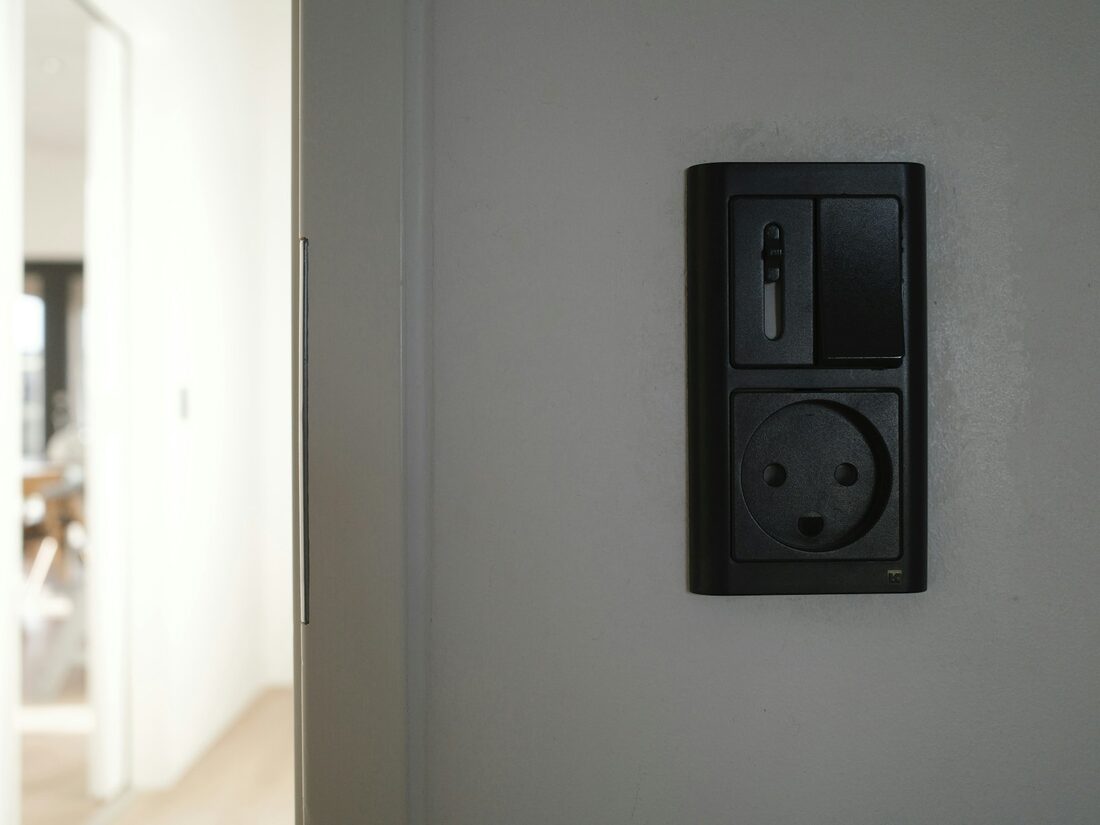 A socket being wired into a back box in a wall